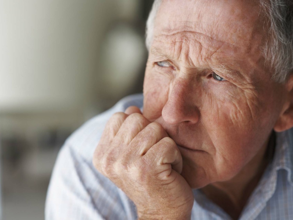 Closeup of an elderly man looking away in deep thought , depression