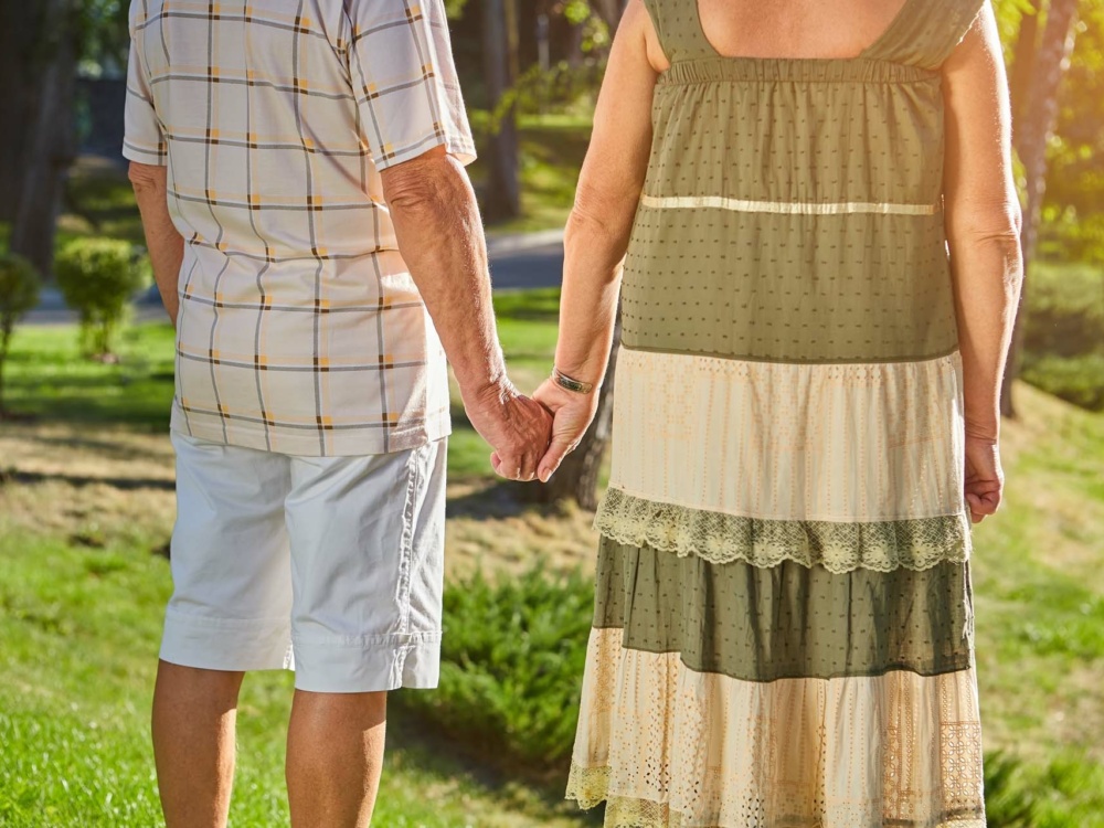 Elderly couple holding hands. Old people on nature background.