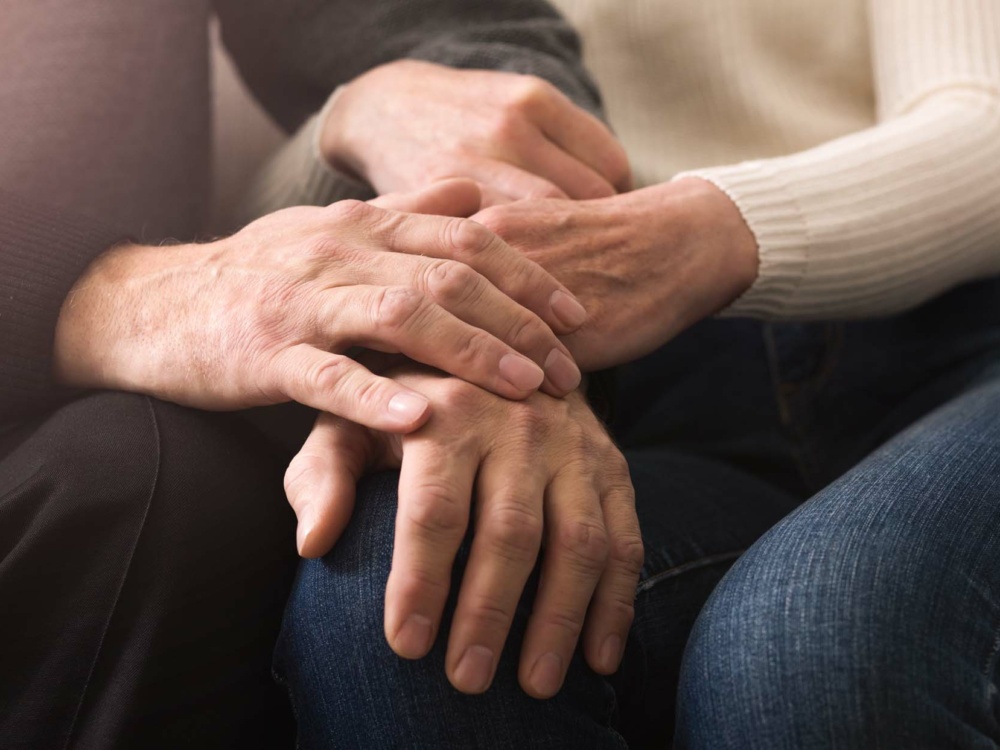 Together till end. Elderly couple holding hands, spending time together at home